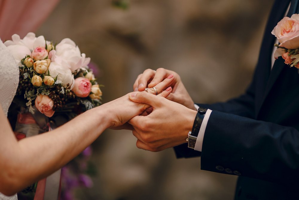 A couple exchanging a ring during their wedding ceremony