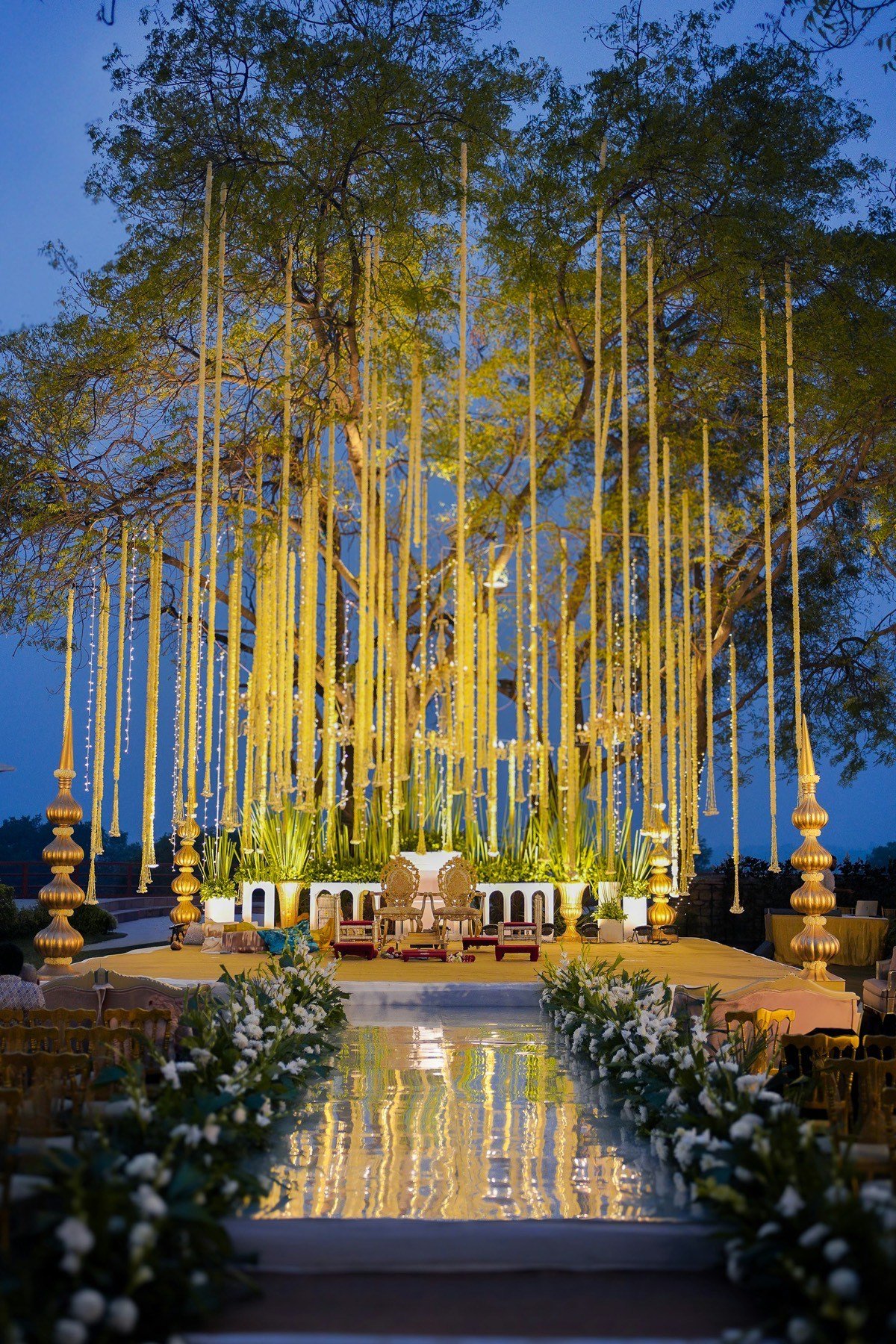 An elegant Indian wedding mandap decorated with marigold garlands and evening lights