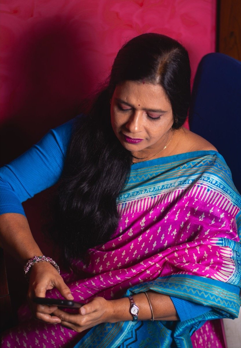 A woman thoughtfully checking a conversation on her phone